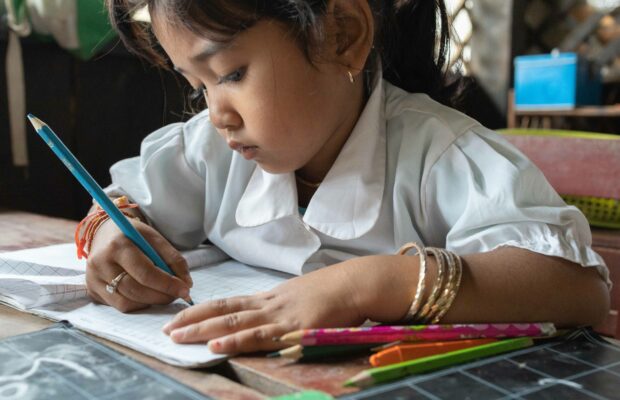 Cambodian girl in school writing