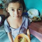 nursery child from Southeast Asia, Inayawan holding bowl of food