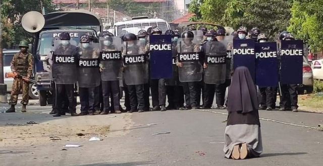 A sister kneeling in front of the police, Myanmar (Burma)